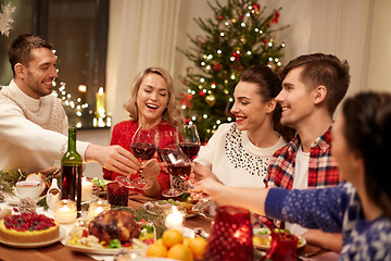 Image showing friends celebrating christmas and drinking wine