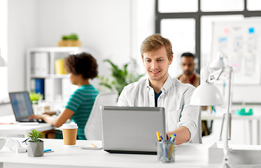 Image showing creative male office worker with laptop