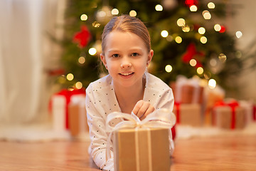 Image showing smiling girl with christmas gift at home