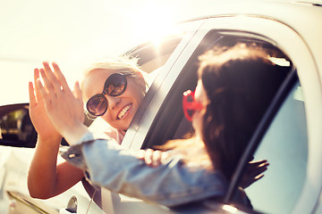 Image showing happy teenage girls or women in car at seaside