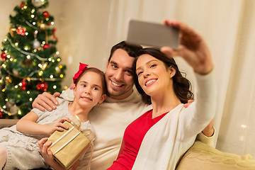 Image showing happy family with christmas present at home