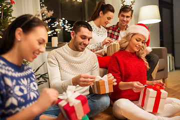 Image showing friends celebrating christmas and opening presents