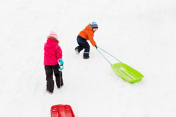 Image showing kids with sleds climbing snow hill in winter