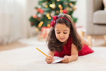 Image showing little girl writing christmas wish list at home