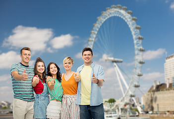 Image showing friends showing thumbs up over ferry wheel