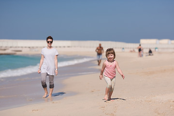 Image showing mother and daughter running on the beach