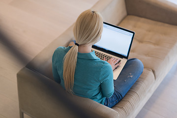 Image showing Young woman using laptop at home