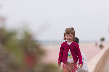 Image showing mother and cute little girl on the promenade by the sea