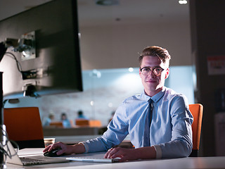 Image showing man working on computer in dark office