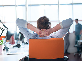 Image showing young businessman relaxing at the desk