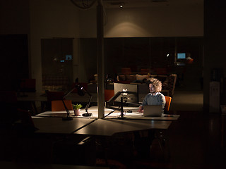 Image showing man working on computer in dark office