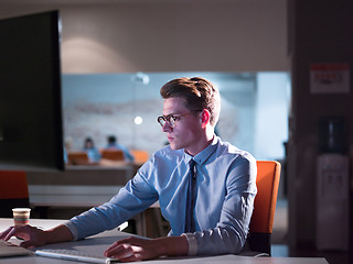 Image showing man working on computer in dark office