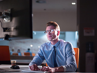 Image showing man working on computer in dark office