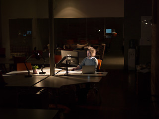 Image showing man working on computer in dark office