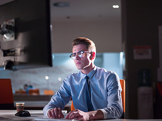 Image showing man working on computer in dark office