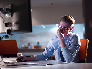 Image showing man working on computer in dark office