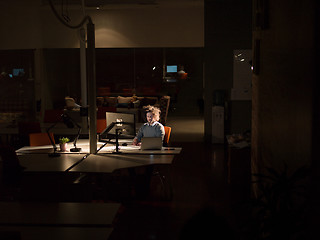 Image showing man working on computer in dark office