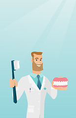 Image showing Dentist with a dental jaw model and a toothbrush.