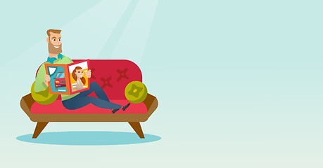 Image showing Man reading a magazine on the couch.