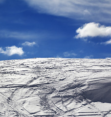 Image showing Off-piste slope with track from ski and snowboard and blue sky w