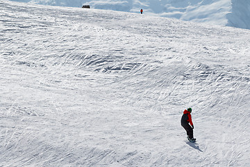 Image showing Snowboarder and skier downhill on snow off-piste slope