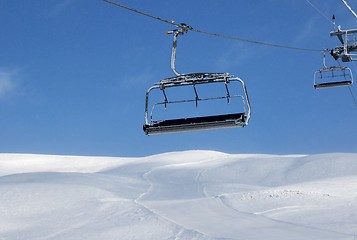 Image showing Ski slope, chair-lift on ski resort and blue sky with falling sn