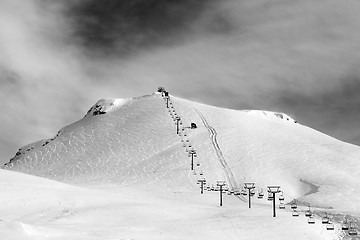 Image showing Black and white view on ski slope and chair-lift at sun winter m