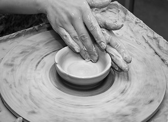 Image showing Woman hands in clay at process of making clay bowl on pottery wh