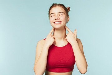 Image showing Woman smiling with perfect smile on the blue studio background