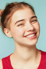 Image showing Woman smiling with perfect smile on the blue studio background and looking at camera