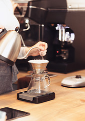 Image showing Hand drip coffee, Barista pouring water on coffee ground with filter