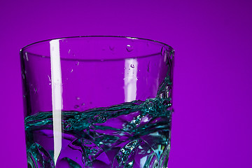 Image showing The water splashing in glass on lilac background