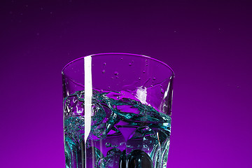 Image showing The water splashing in glass on lilac background