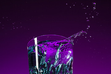 Image showing The water splashing in glass on lilac background