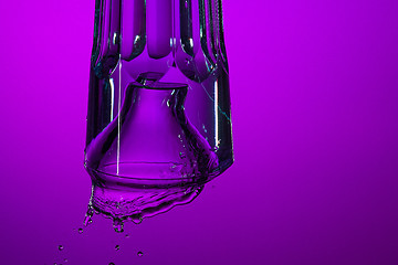 Image showing The water splashing in glass on lilac background