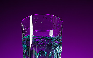 Image showing The water splashing in glass on lilac background