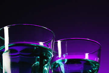 Image showing The water in two glassese on lilac background