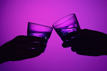 Image showing Two wine glasses and male and female hands.