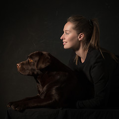 Image showing The young woman hugging a mix breed dog