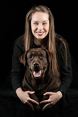 Image showing The young woman hugging a mix breed dog