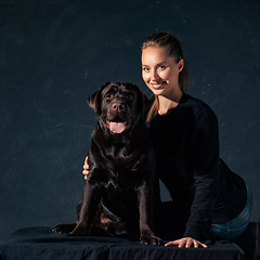 Image showing The young woman hugging a mix breed dog