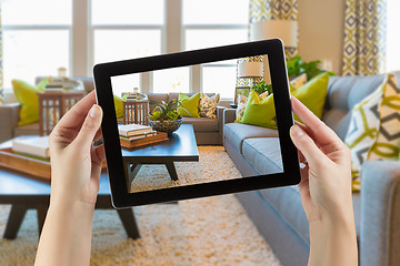 Image showing Female Hands Holding Computer Tablet In Room with Photo on Scree