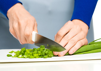 Image showing Cook is chopping green onion