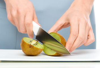 Image showing Cook is chopping kiwifruit