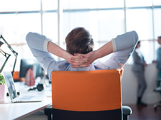 Image showing young businessman relaxing at the desk