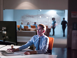 Image showing man working on computer in dark office