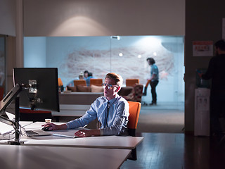 Image showing man working on computer in dark office