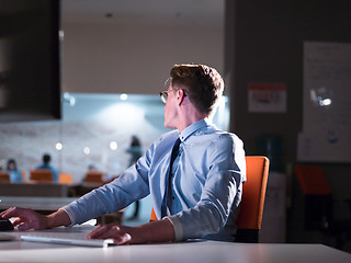 Image showing man working on computer in dark office