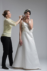 Image showing Beautiful young bride wears dress by stylist