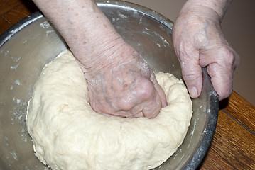 Image showing elderly hands knead the dough